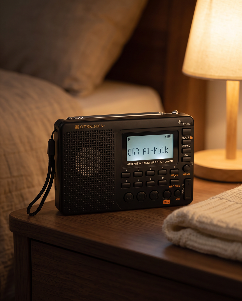 Radio OTERINKA le soir sur une table de chevet, écran affichant 067 Al-Mulk