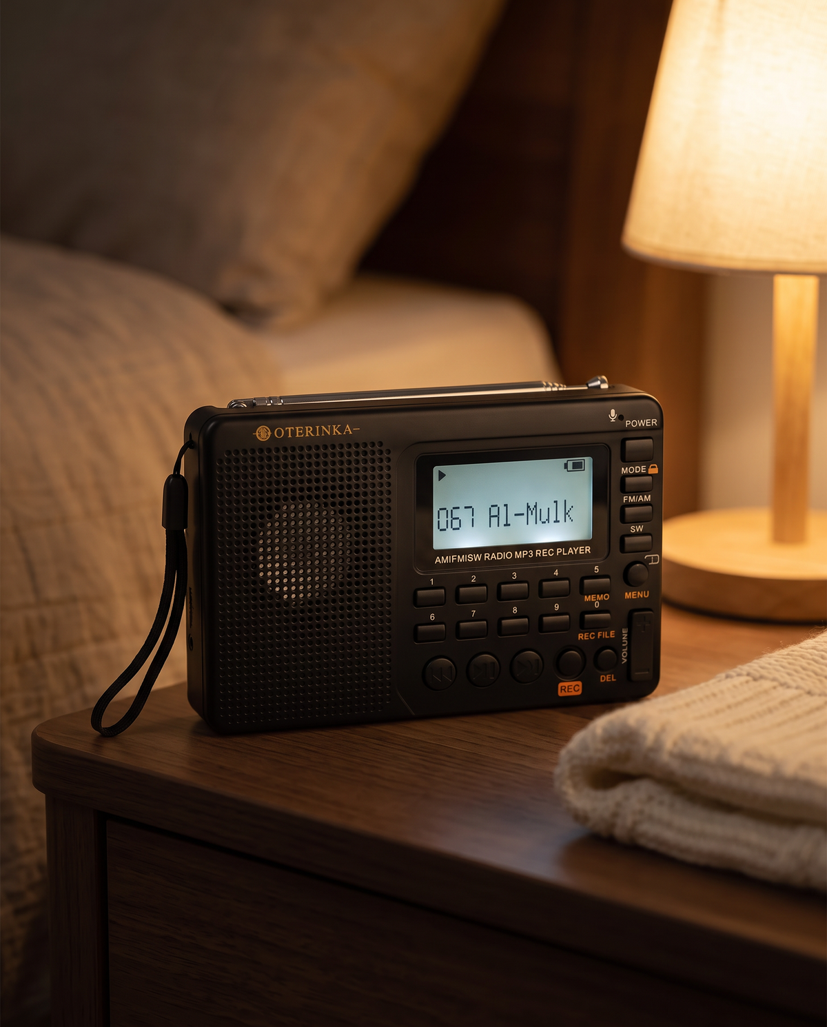 Radio OTERINKA le soir sur une table de chevet, écran affichant 067 Al-Mulk